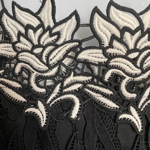 It’s a black and white off shoulder top with an embroidered flower design. - Picture 7 of 7